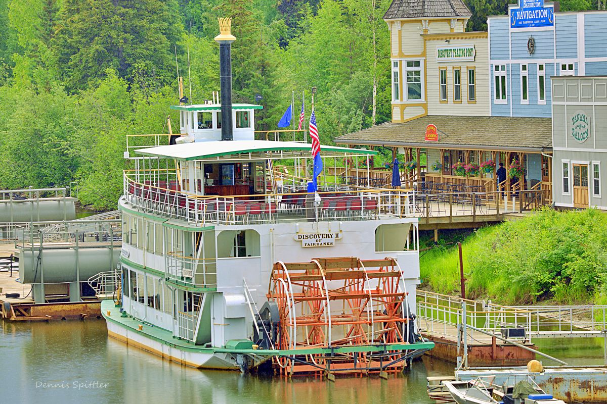 Discovery II sternwheeler paddleboat docked on Chena River in Fairbanks Alaska with trading post in background